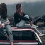 Eco-Friendly Fashion - Two Women Sitting on Vehicle Roofs