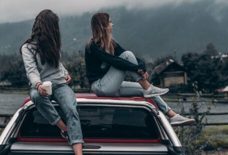 Eco-Friendly Fashion - Two Women Sitting on Vehicle Roofs