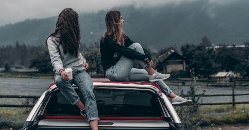 Eco-Friendly Fashion - Two Women Sitting on Vehicle Roofs