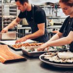Meal Kit Services - Man and Woman Wearing Black and White Striped Aprons Cooking