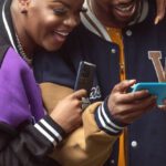 Fashion Tech - Man and Woman with Smartphones Laughing