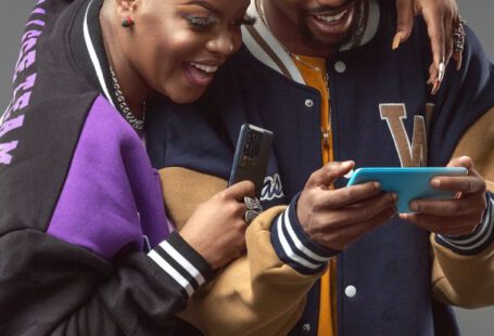 Fashion Tech - Man and Woman with Smartphones Laughing