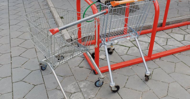 Private Sale Events - Shopping trolleys attached to metal stand near supermarket on street